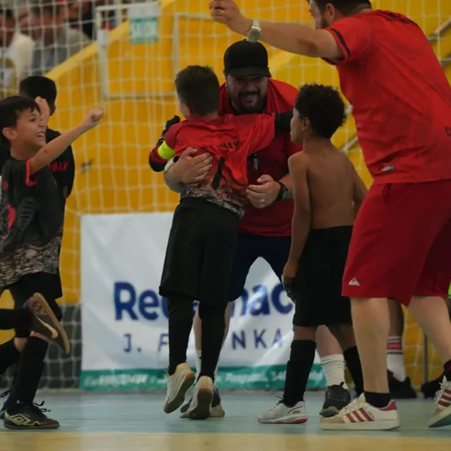 Professor Gustavo abraçando atletas após gol em competição